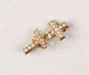 A cross and crown brooch given to Laura Lathrop by Mary Baker Eddy